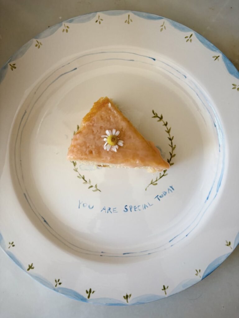 Slice of daisy cake on a hand painted plate that says You Are Special Today