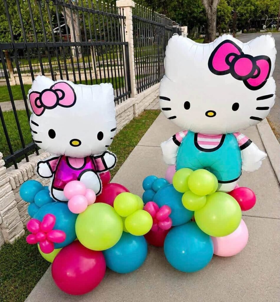 Two Hello Kitty balloon sculptures standing on colorful balloon bases in pink, lime and teal