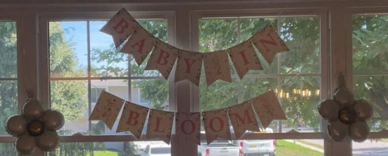 Burlap Baby in Bloom banner with fabric flowers hanging in a window