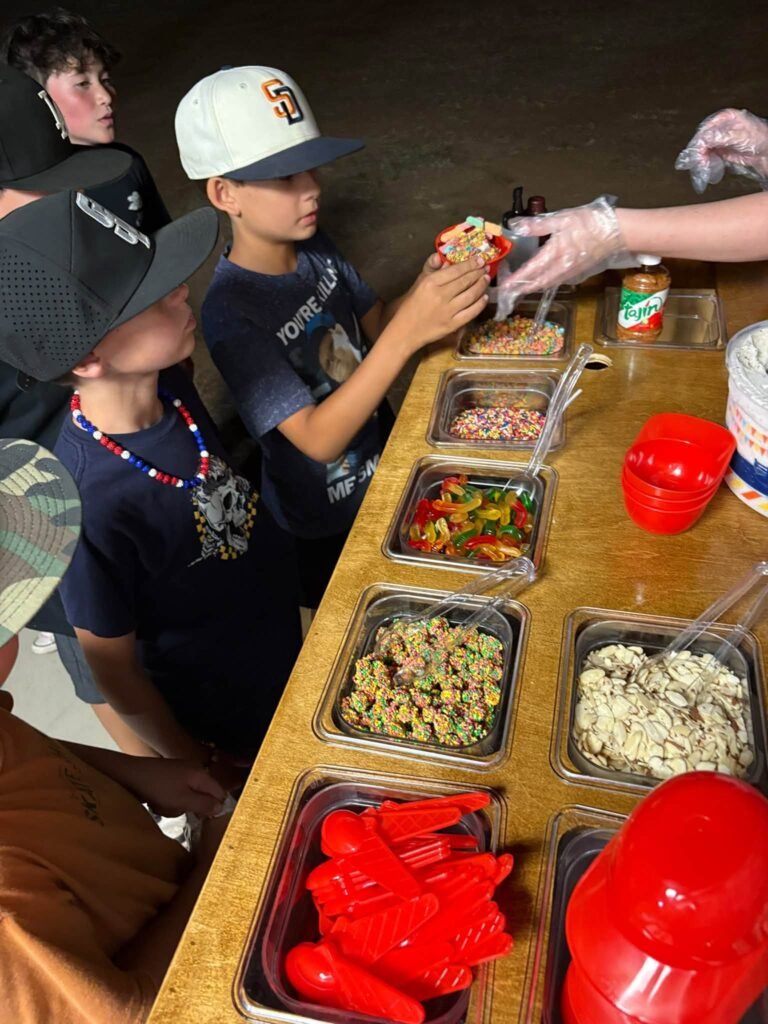 Kids building sundaes at a baseball birthday topping bar