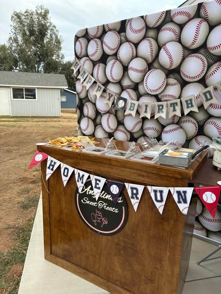 Baseball birthday Home Run snack stand with a pennant banner in front of a baseball wall backdrop