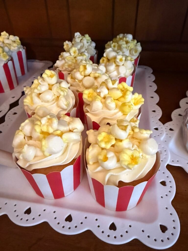 Close up of popcorn topped cupcakes in red and white striped liners