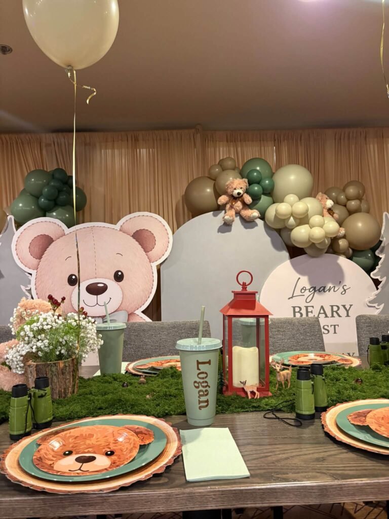 Teddy bear cutout, red lantern and bear face plate on a woodland party table