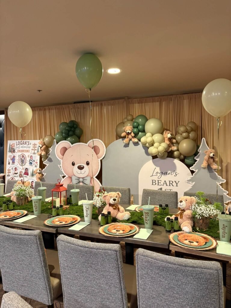 Long teddy bear birthday table with bear cutout board, balloon garland and wood slice chargers