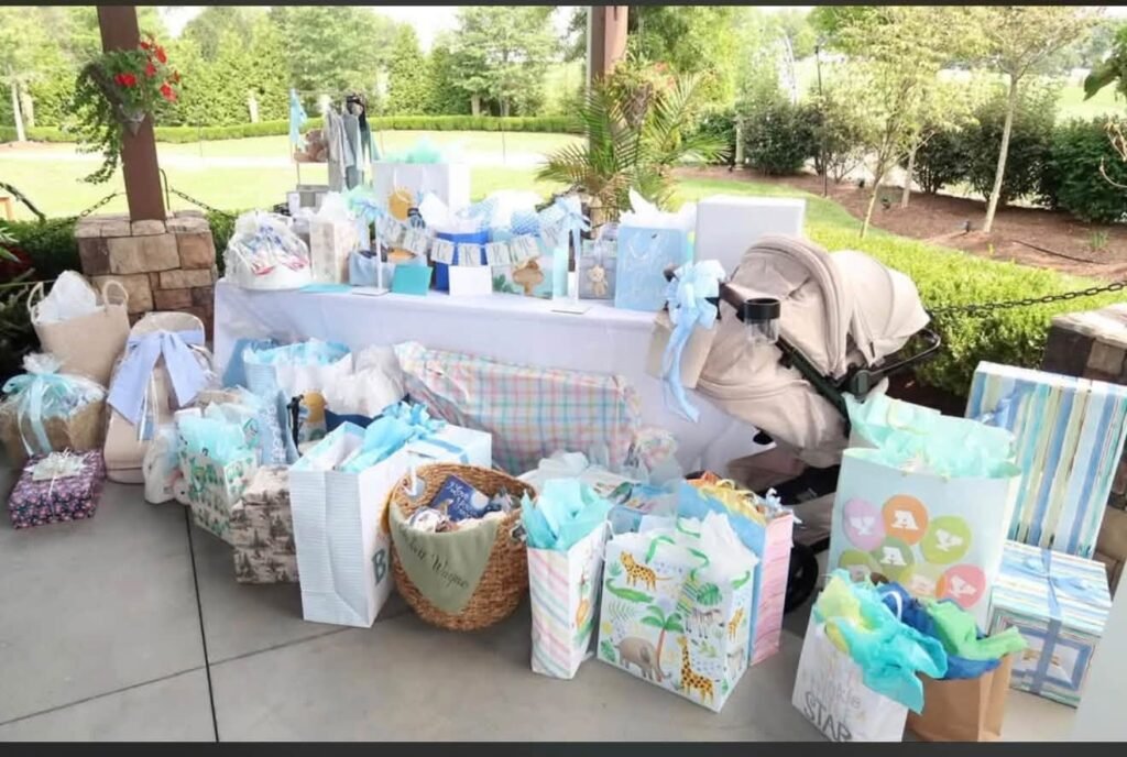 Outdoor gift table full of baby shower presents on a lawn