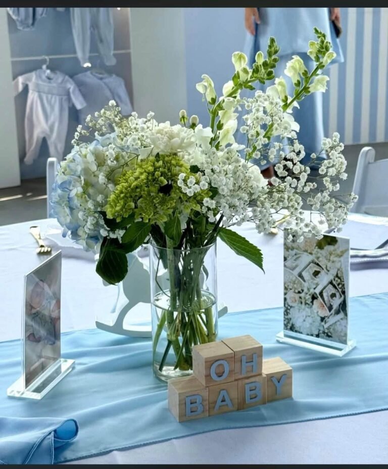 White hydrangea centerpiece with baby blocks on a blue table runner