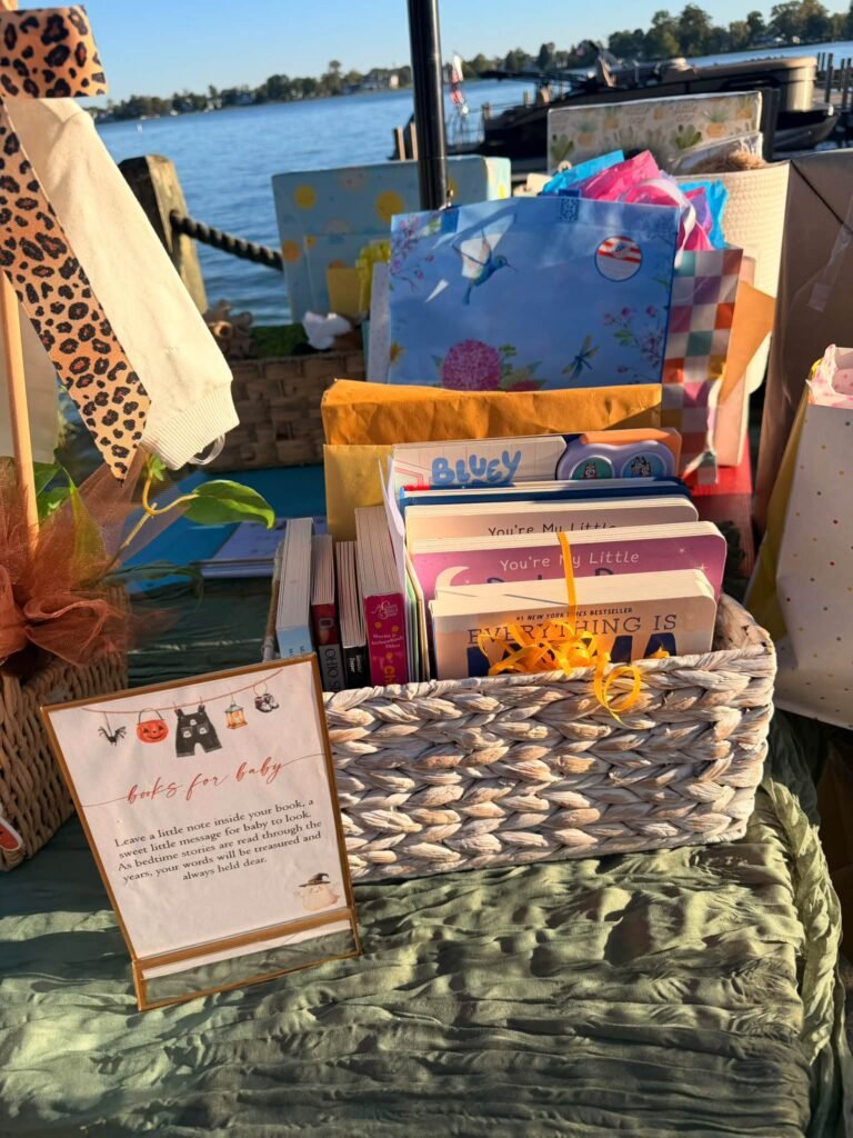 Books for baby basket filled with children books next to a small sign at a baby shower