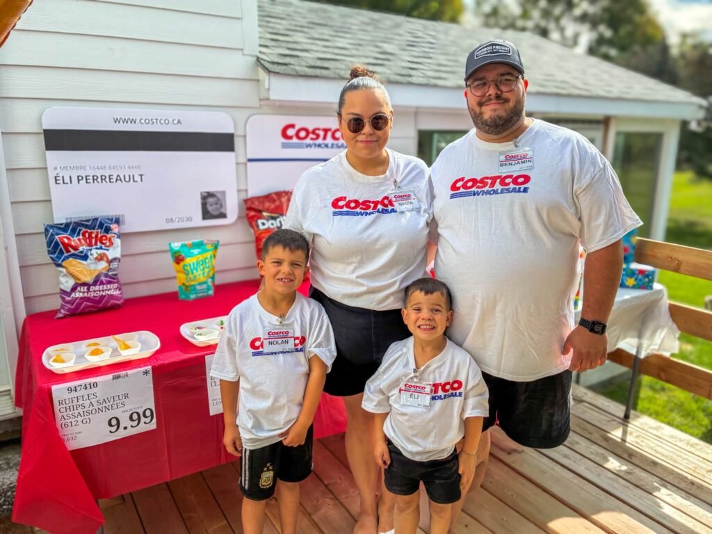 Family in matching Costco shirts in front of the party snack table