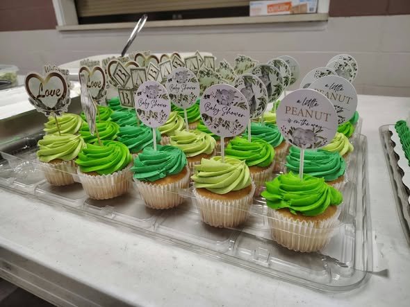 Green frosted cupcakes with elephant toppers for a Little Peanut baby shower