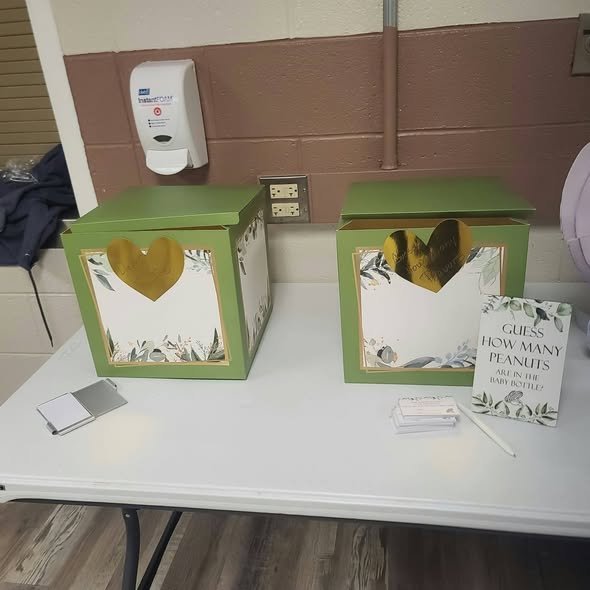 Green and white boxes with a guess how many peanuts sign and entry cards on a table