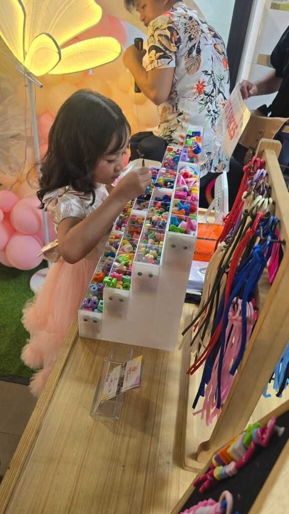 Girl choosing charms at a souvenir charm booth at a birthday party