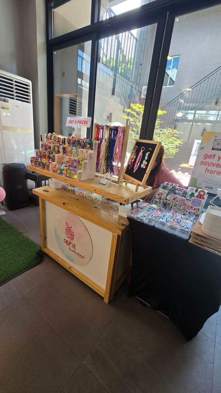 Souvenir charm booth with a wood stand of charms and bracelets at a birthday party