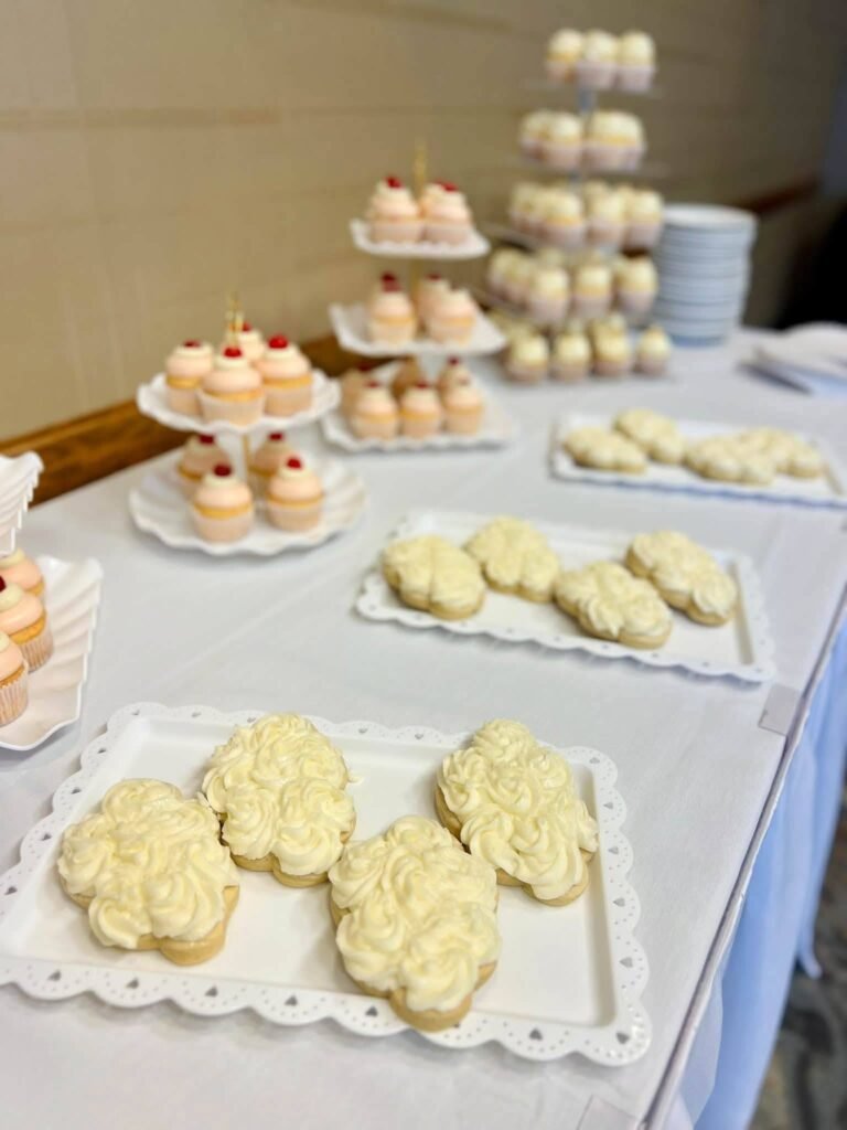 Heaven Sent baby shower dessert table with cloud shaped cookies, cupcake towers and white trays