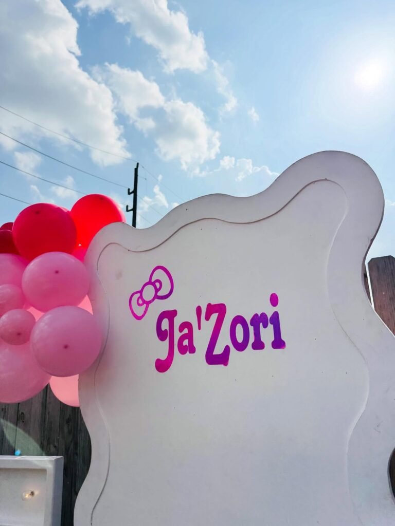 Custom name sign with a Hello Kitty bow and pink balloons