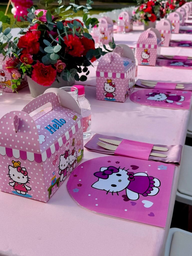 Hello Kitty place setting with a pink treat box, a Hello Kitty placemat and cutlery in a pink napkin