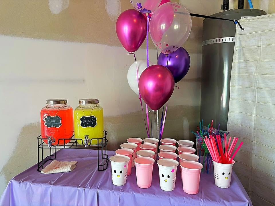 Lemonade drink station with two drink dispensers, chalkboard labels, Hello Kitty cups and pink straws