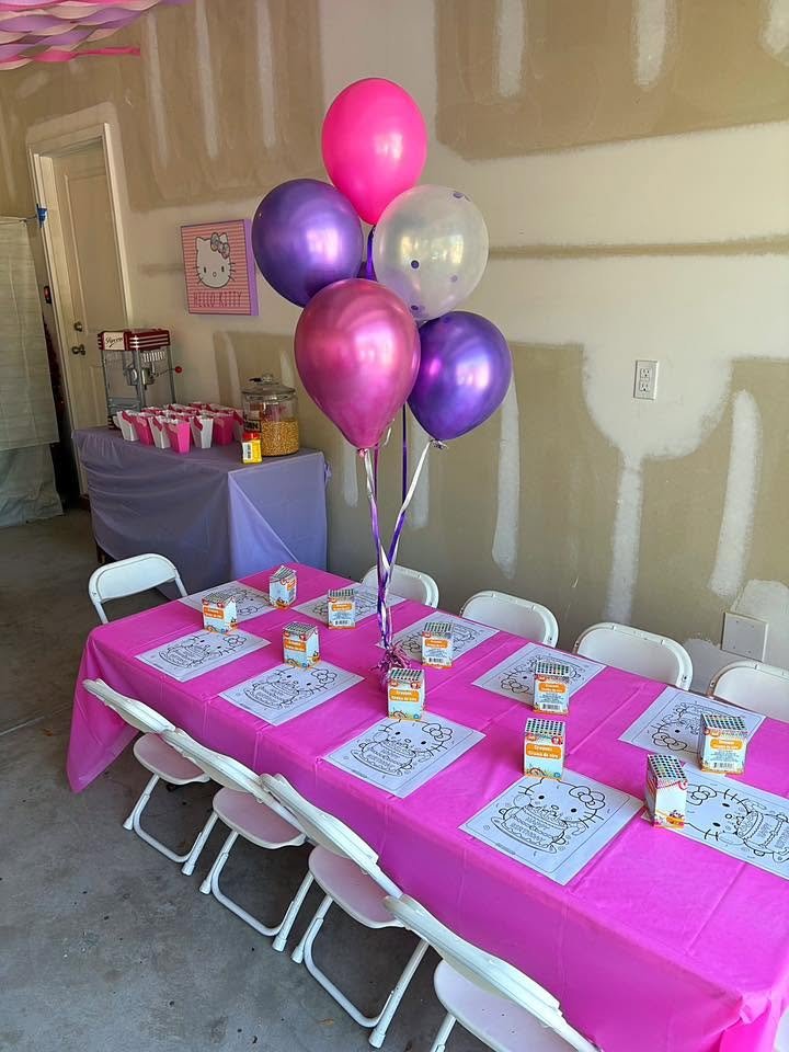 Hot pink kids table with purple and pink balloon bunch and Hello Kitty place settings