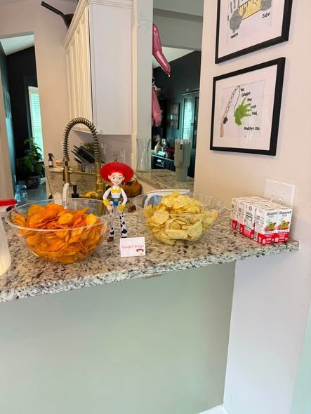 Toy Story snack counter with chips in glass bowls, juice boxes and a Jessie figure