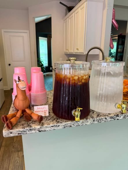 Toy Story drink station with iced tea and lemonade dispensers, pink cups and a Bullseye toy
