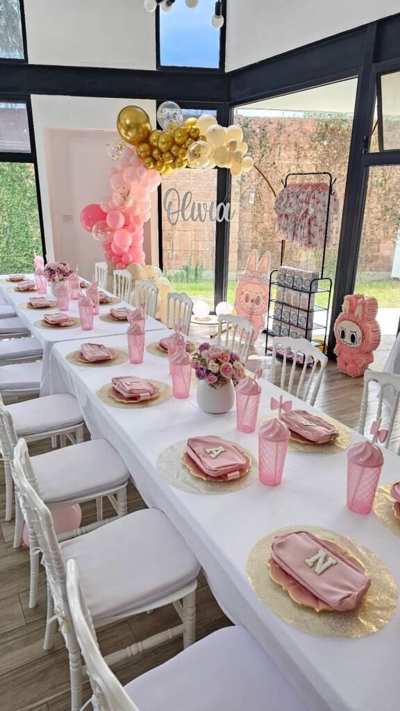 Long pink Labubu party table with white chairs and pink place settings