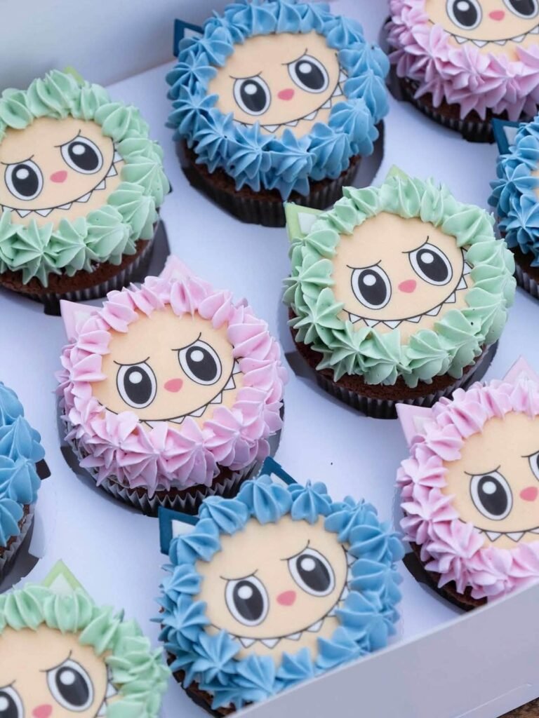 Labubu face cupcakes in pink, blue and green frosting