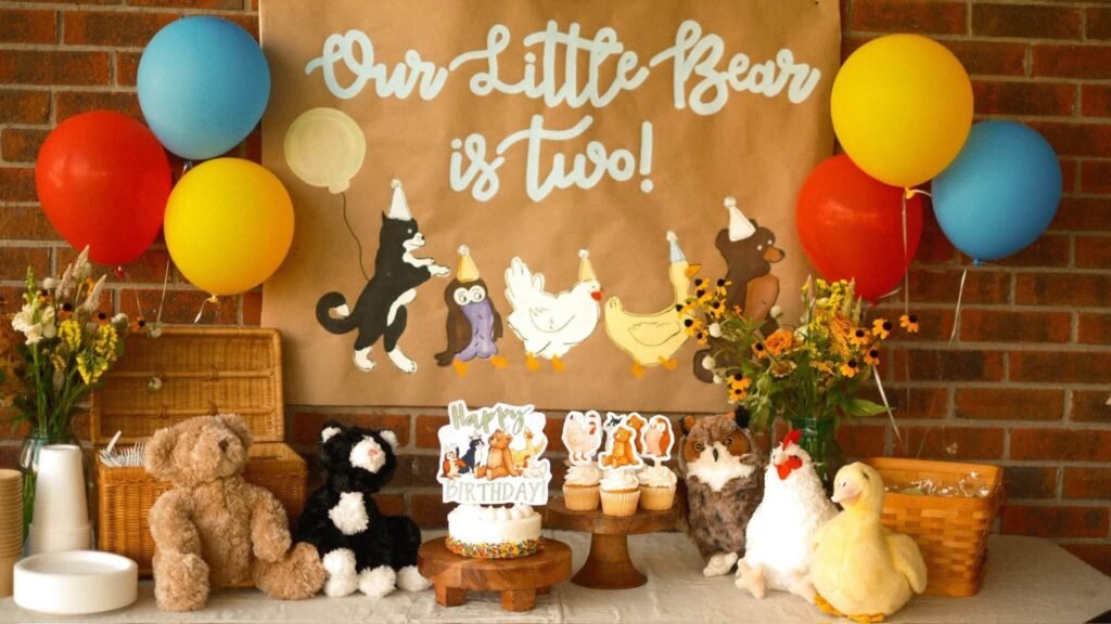 Our Little Bear Is Two 2nd birthday table with a kraft paper banner, animal cutouts and balloons