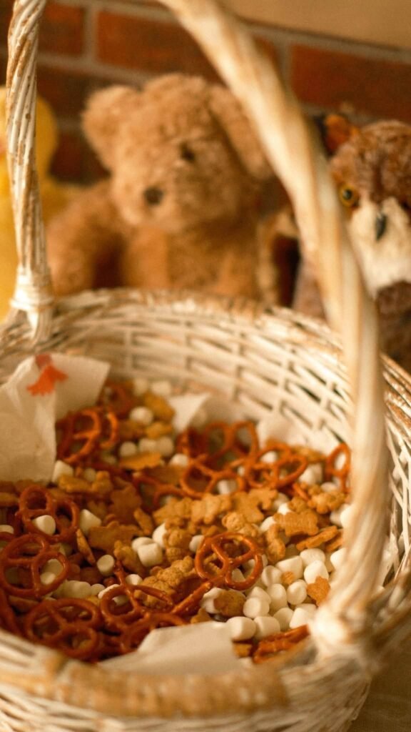 Teddy bear holding a basket of trail mix snacks