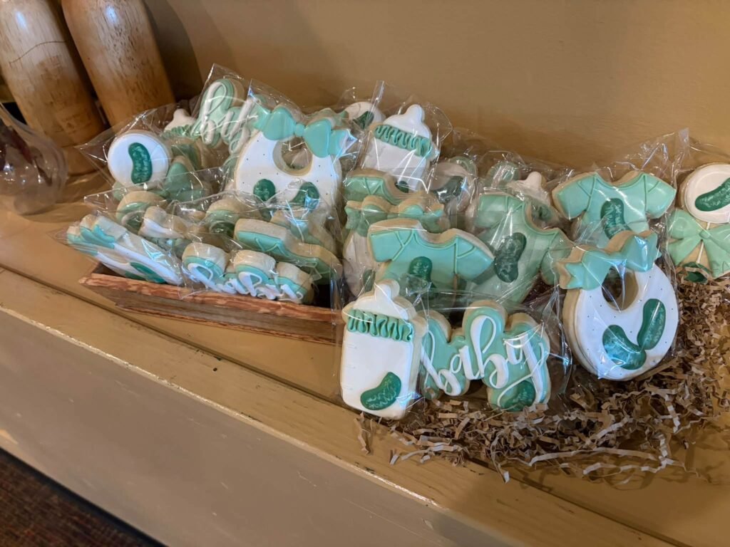 Pickle and onesie sugar cookies in a basket for a Little Pickle shower