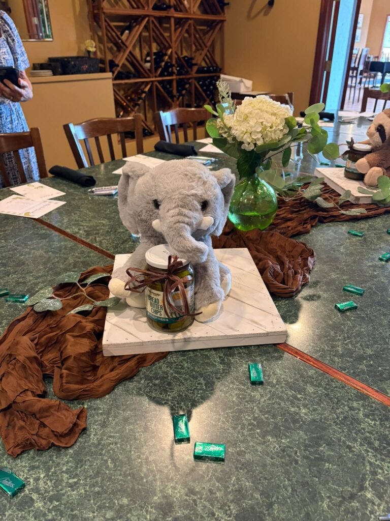 Elephant plush centerpiece with baby breath and green candy on the table