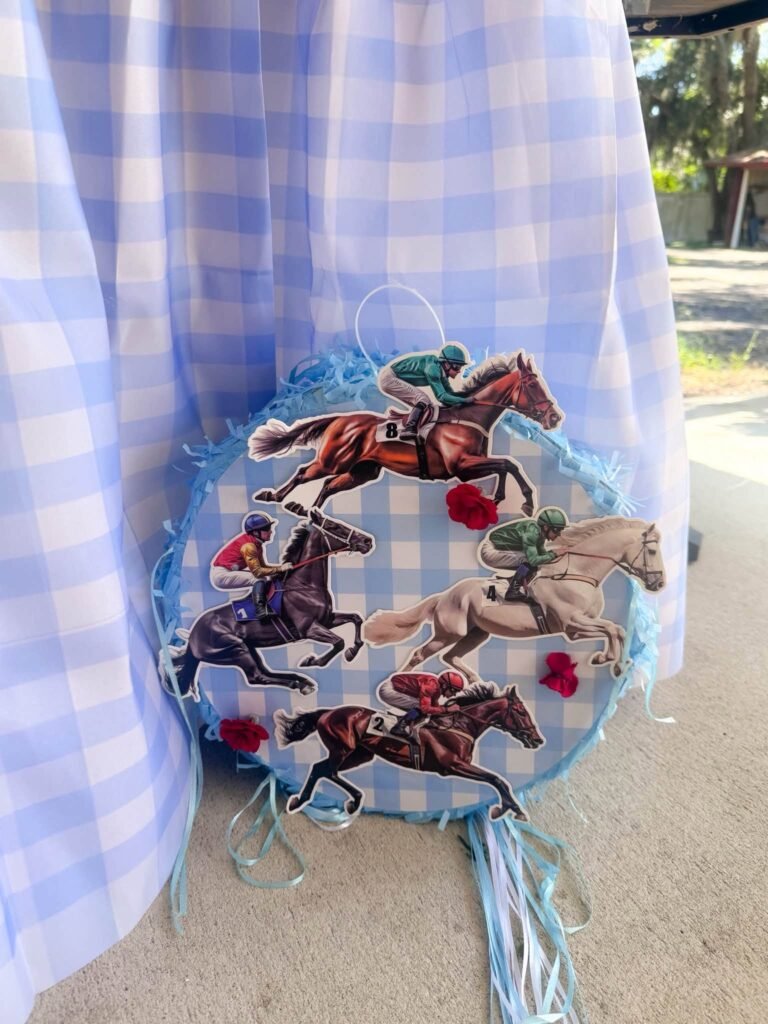 Horse race wreath with jockey figures and blue ribbon on a gingham table