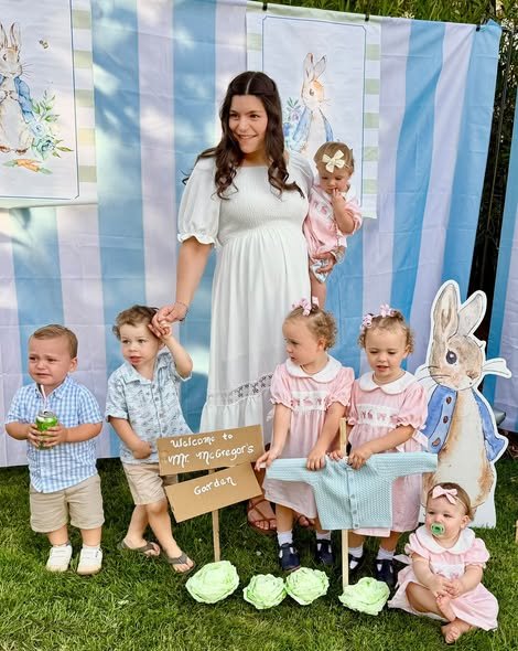 Mom to be with toddlers by a Peter Rabbit backdrop with blue stripes and cabbage decor