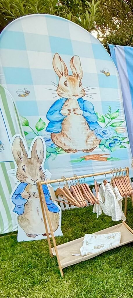 Peter Rabbit panels with a baby clothing rack and small sign