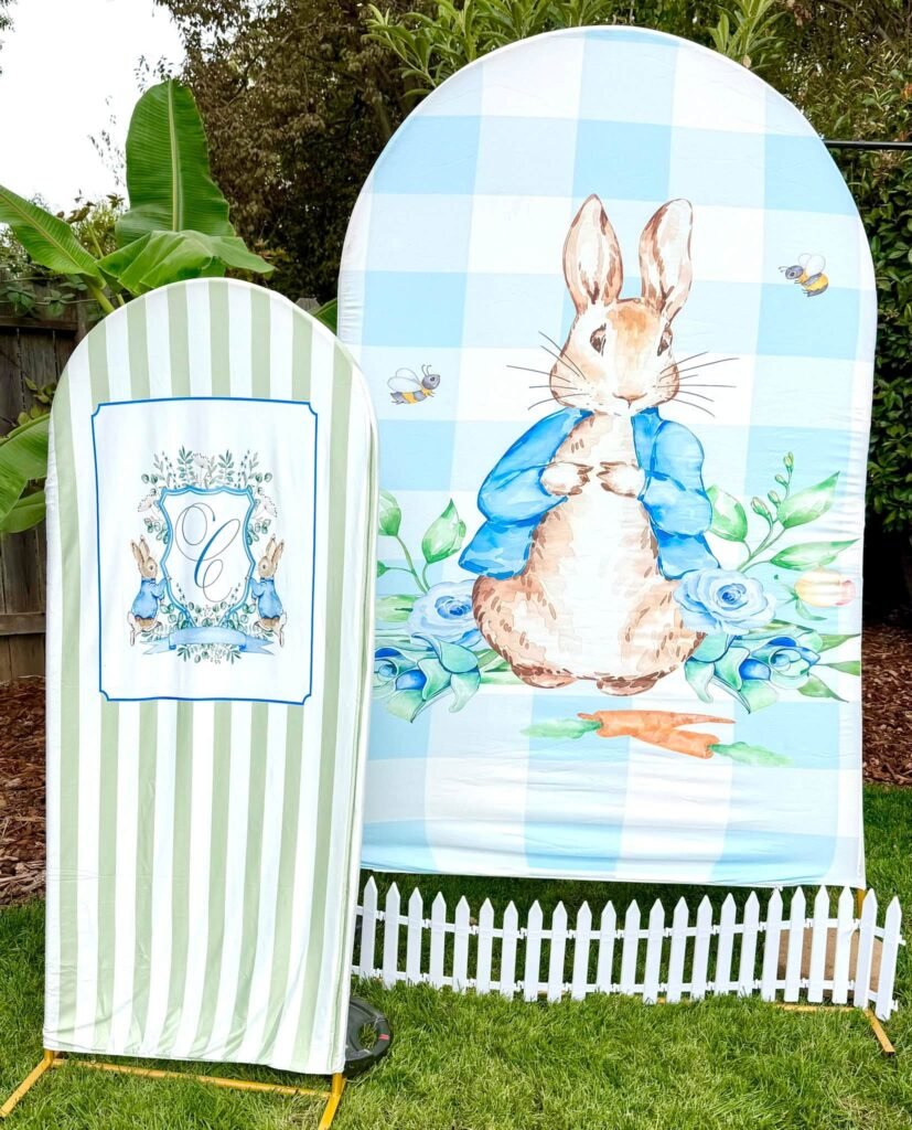 Peter Rabbit baby shower arch panels in blue gingham and green stripes with a picket fence