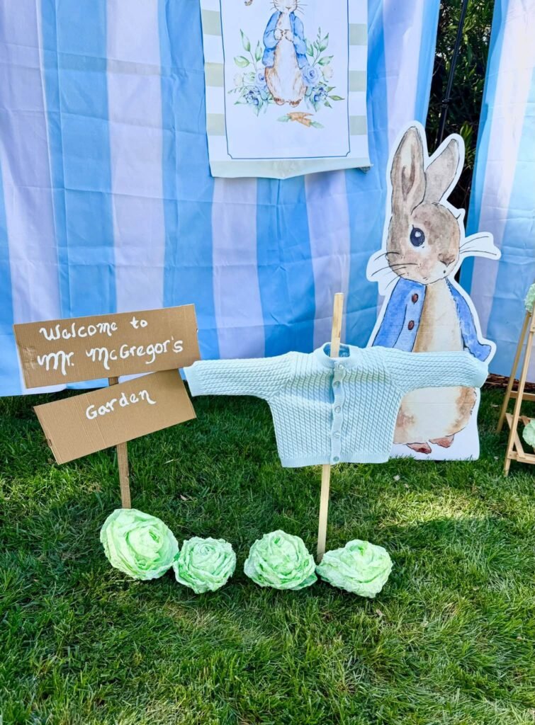 Mr McGregor garden sign with lettuce heads and a blue sweater on a fence