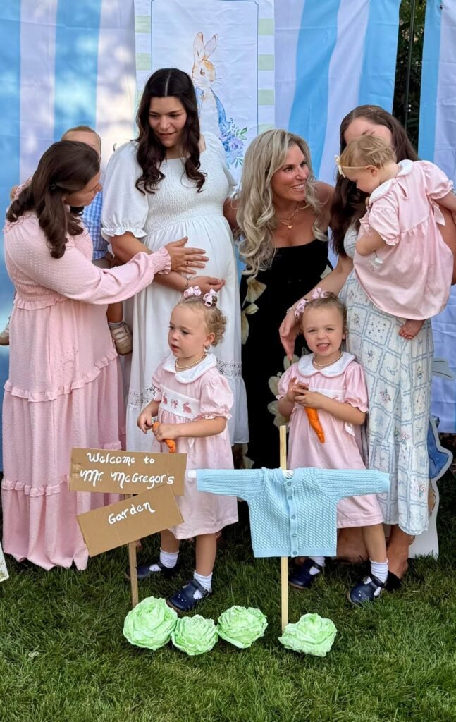 Mom to be with family and toddlers in front of a Peter Rabbit backdrop
