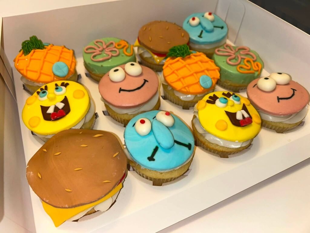 SpongeBob themed cupcakes with pineapple, Patrick, Squidward and Krabby Patty toppers in a white box