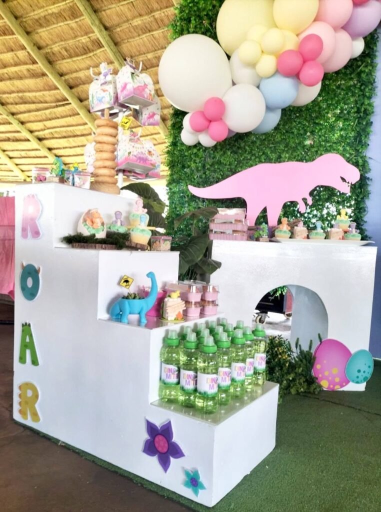 White ROAR cube stand with Dino Mite bottles and a pink dinosaur arch