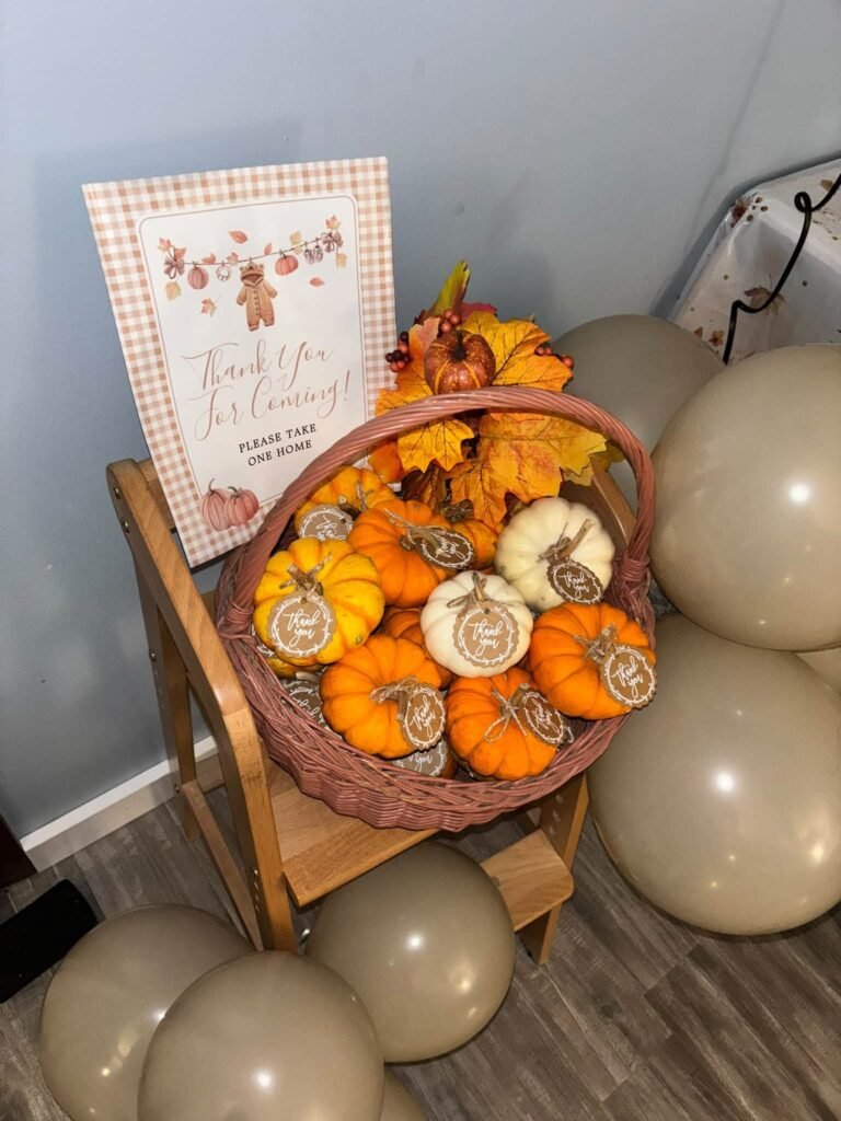 Thank you for coming sign next to a basket of mini pumpkins with tags on a wooden chair