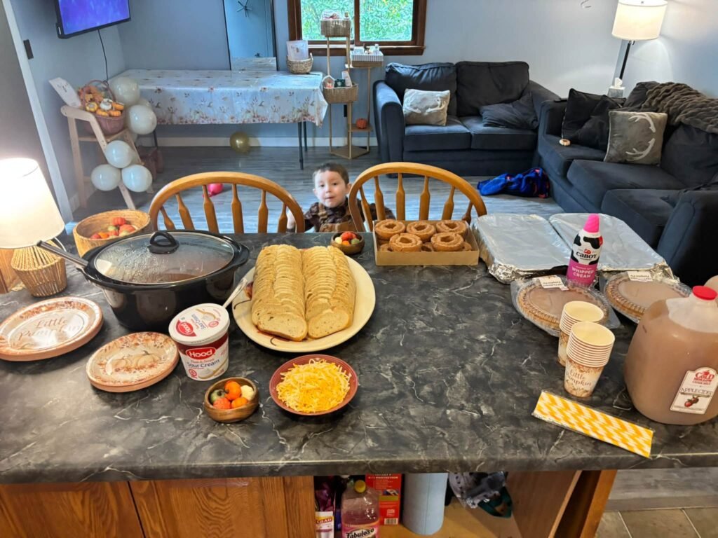 Home kitchen counter with party food and plates at a DIY pumpkin baby shower