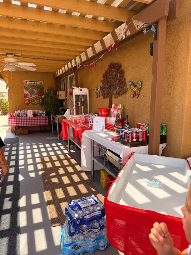 Covered patio set for a Ready to Pop baby shower with red gingham tables