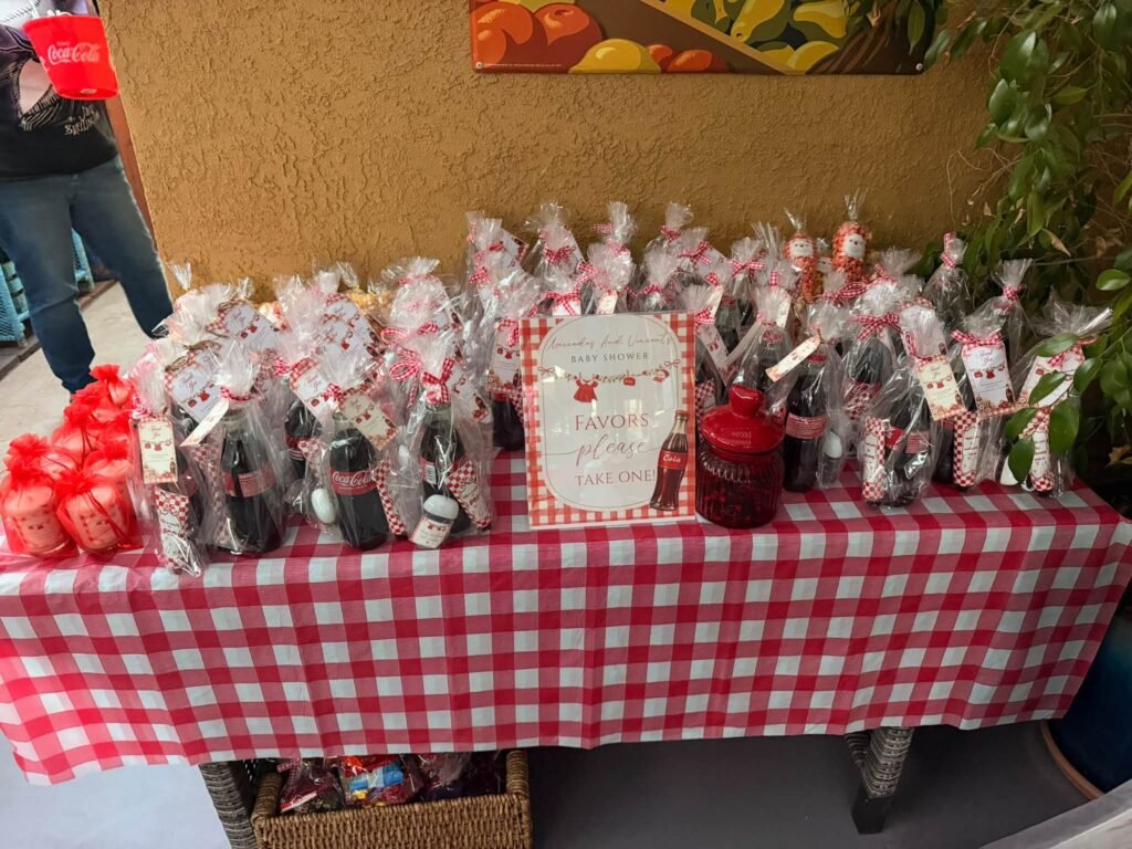 Red gingham favor table with popcorn and treat bags and a Ready to Pop sign