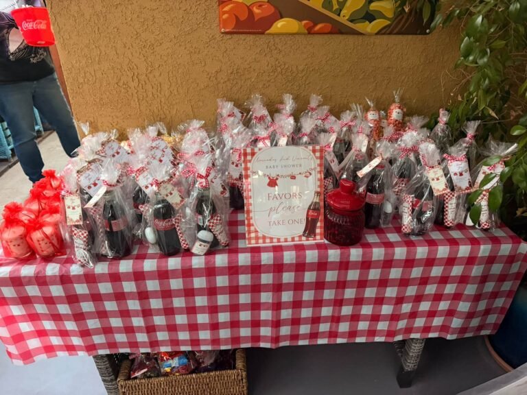 Red gingham favor table with popcorn and treat bags and a Ready to Pop sign