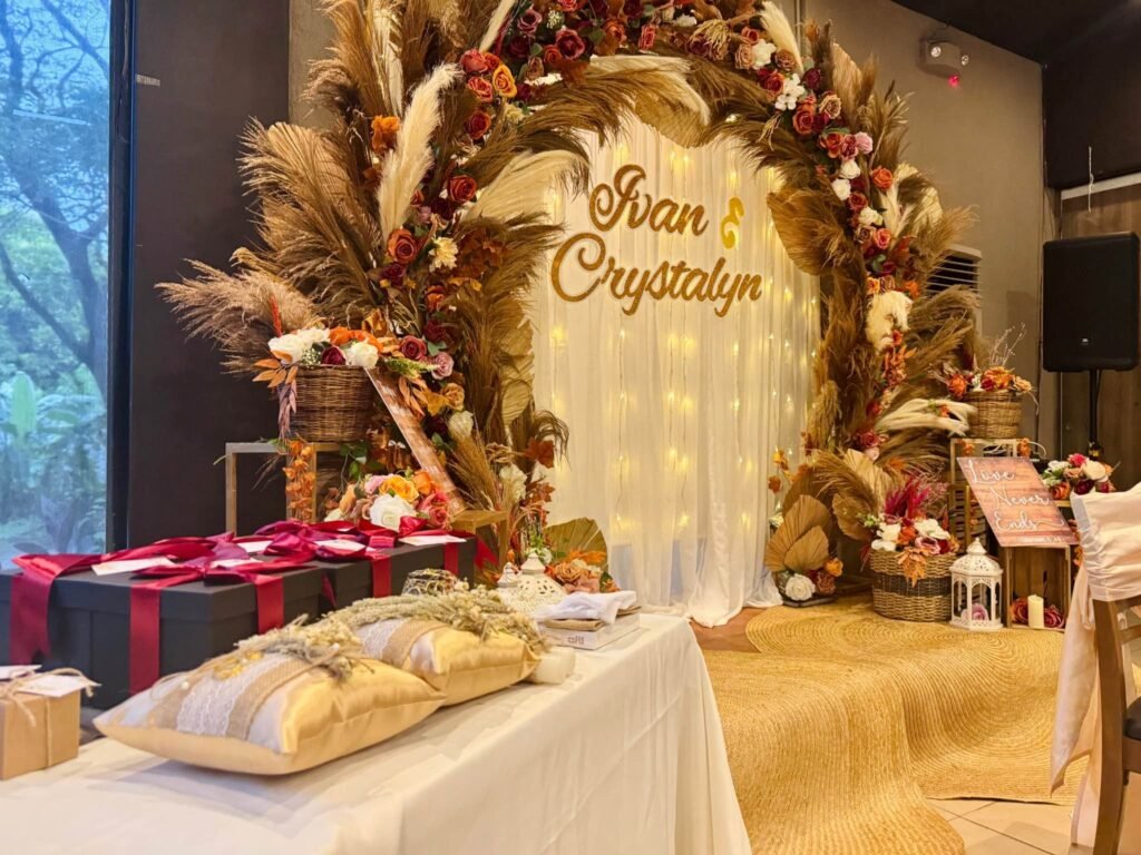 Gift table with a ring pillow and gift boxes in front of a pampas wedding arch