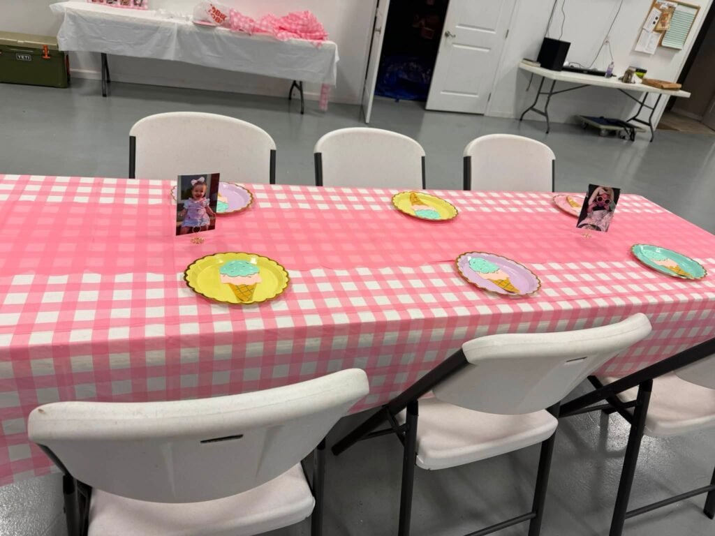 Pink gingham guest table with donut plates and white chairs