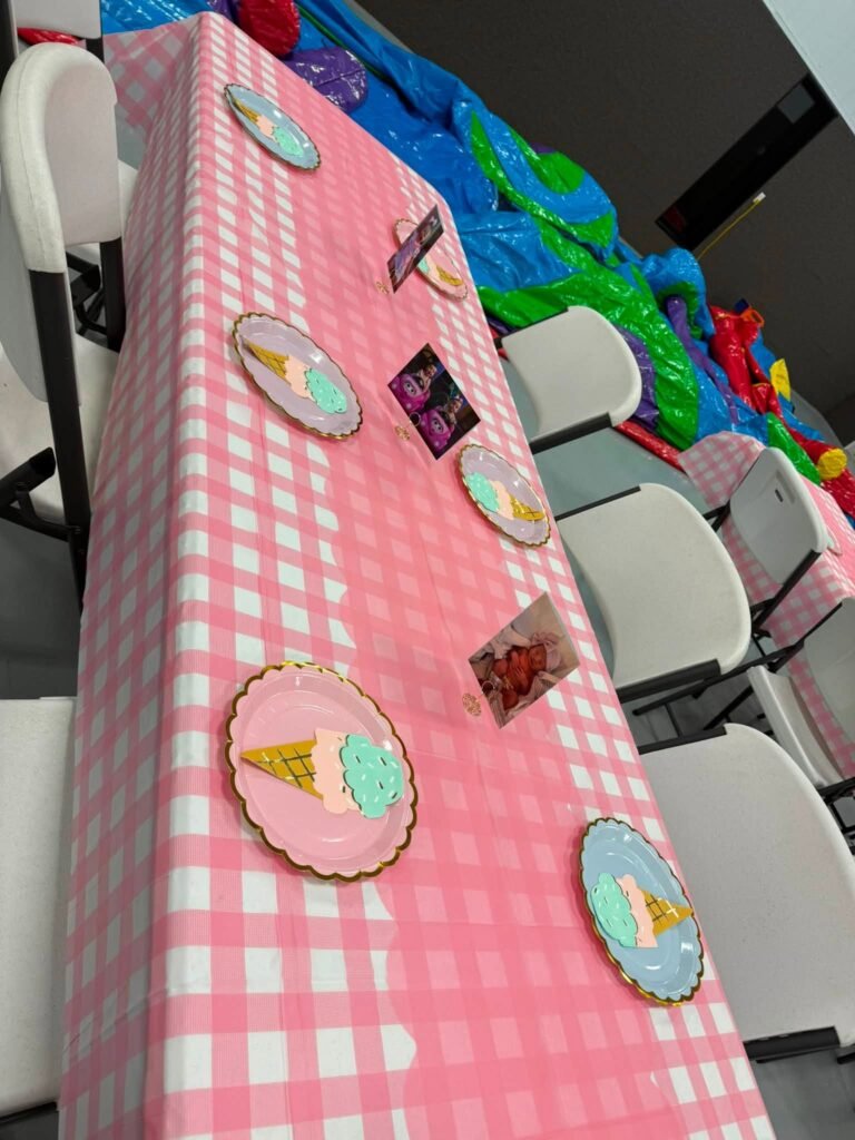 Long pink gingham party table with donut plates and sprinkle napkins