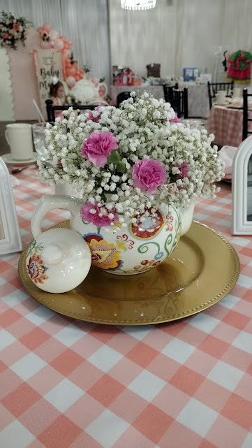 Floral teapot centerpiece with pink roses and baby breath on a gold charger and pink gingham