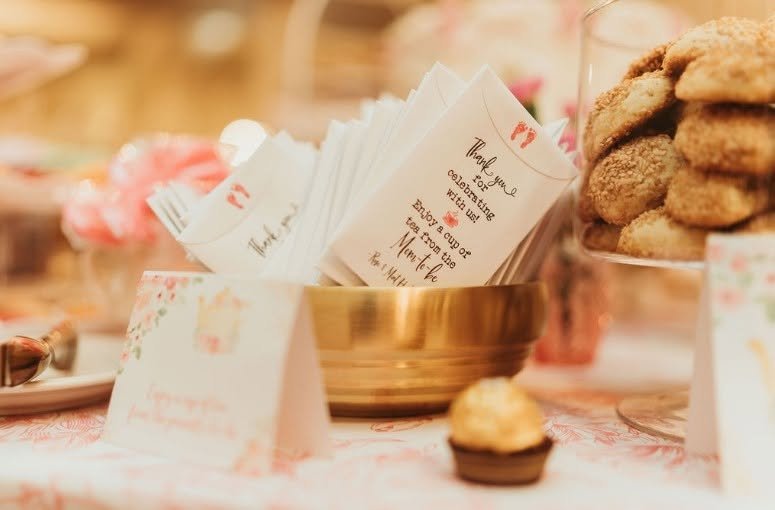 Thank you cards and cookies on a pink tea party baby shower table