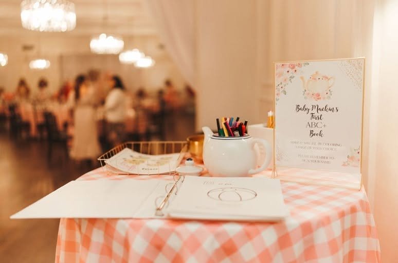 Baby ABC book guest table with pink gingham, a teapot and colored pencils