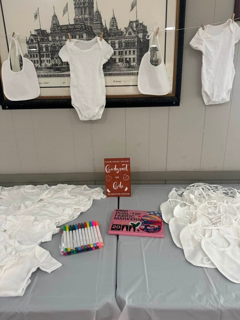 Decorate a onesie station with white onesies, bibs and fabric markers