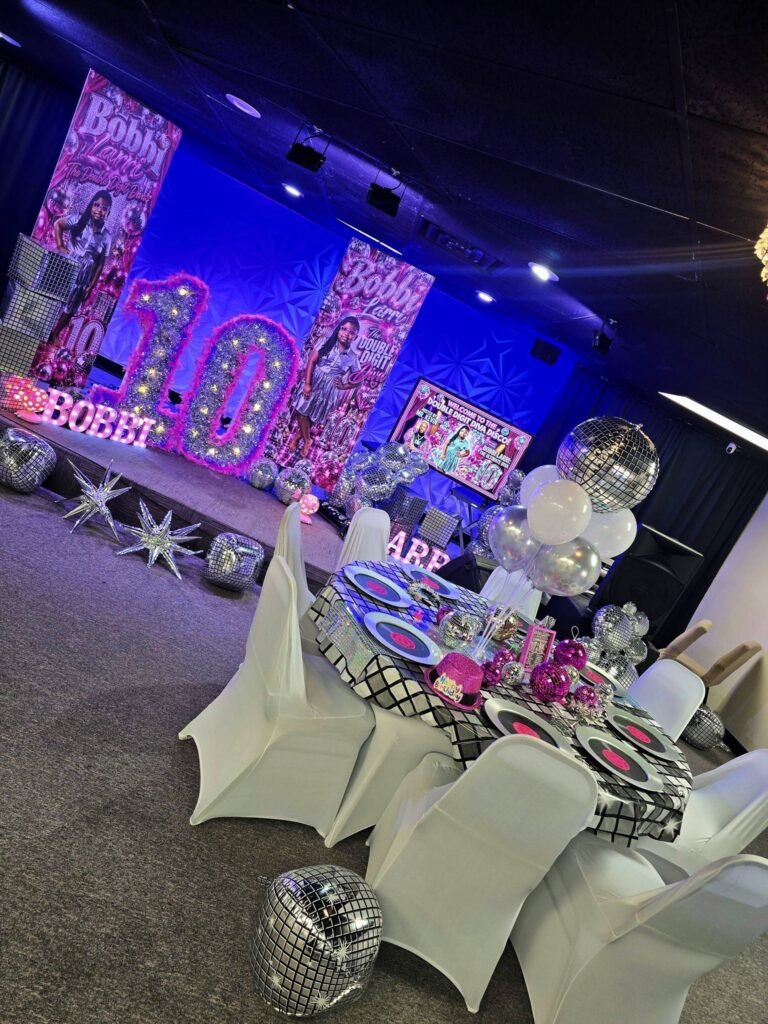 Pink and silver disco 10th birthday party room with light up number 10 and mirror balls